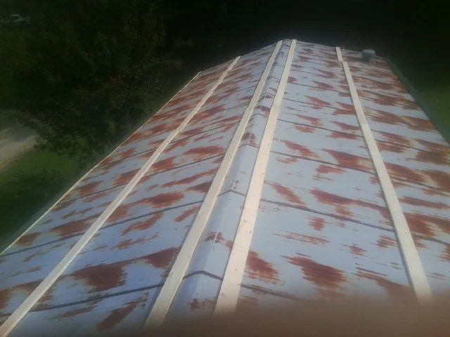 Rusted metal roof panels with new wood purlins before replacement — Storm Damage Roof Repair in Ogema by Roofing Brothers