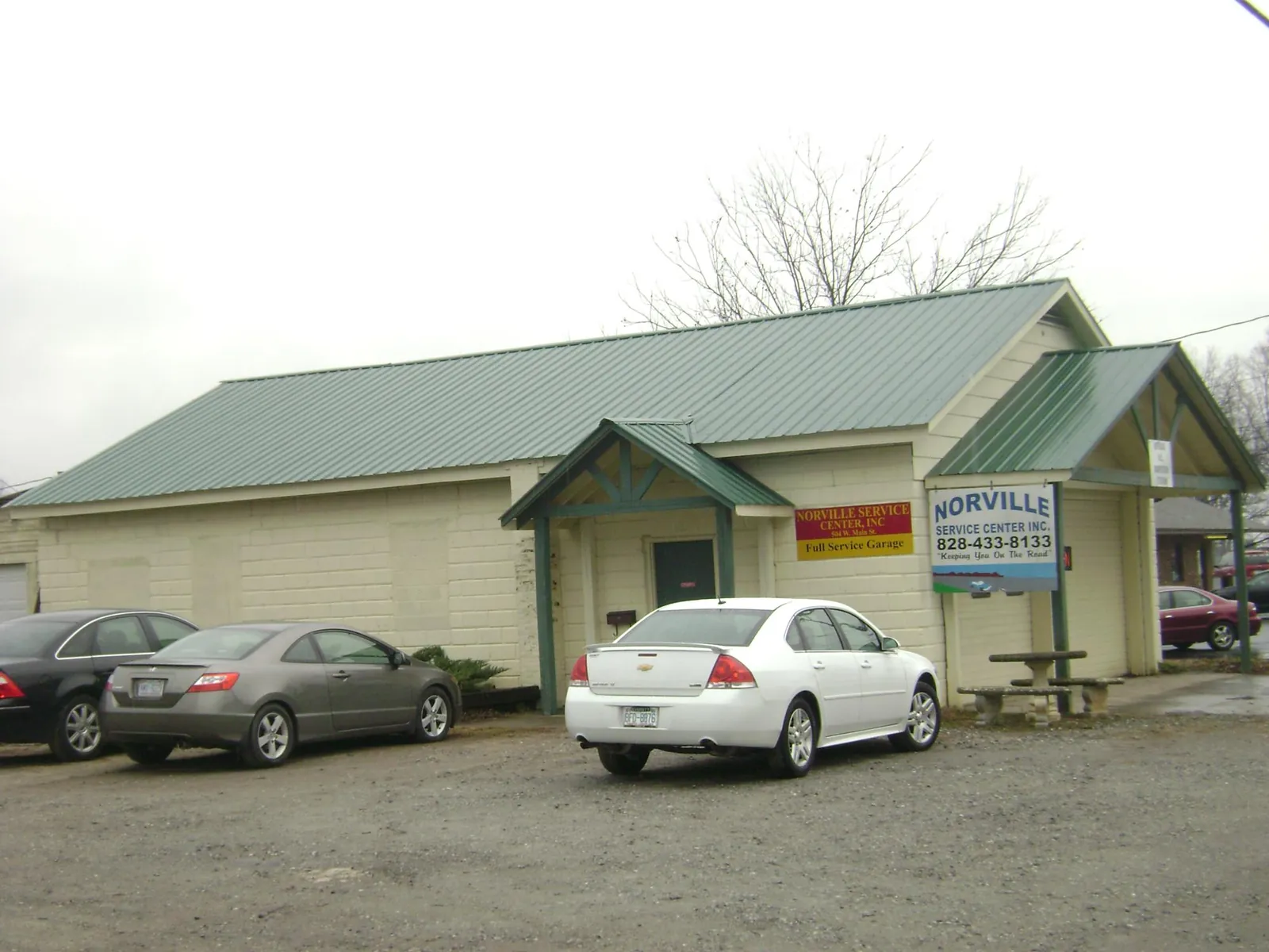 Green metal roof on a service garage with a covered entry in Ogema