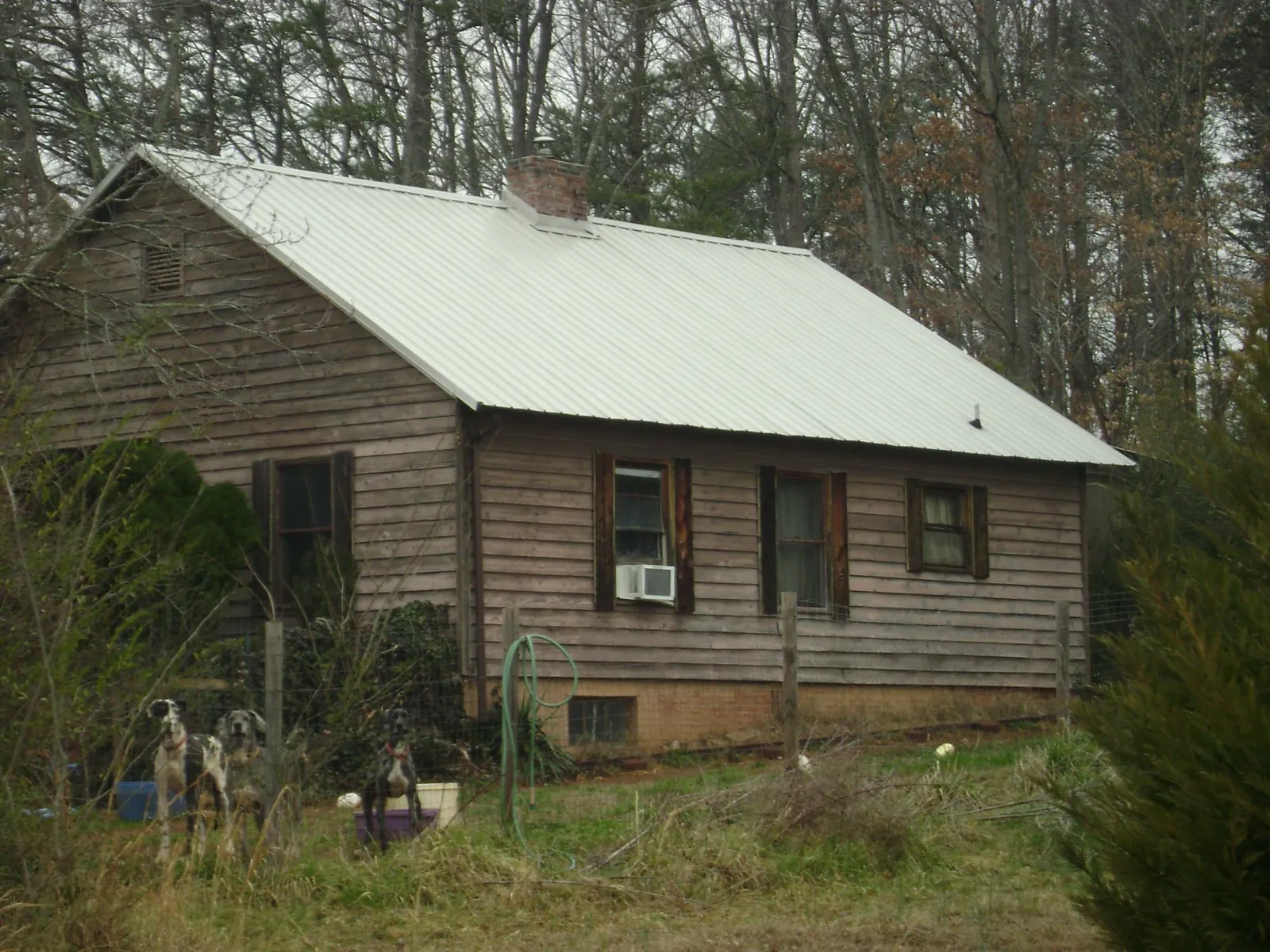 White metal roof on an old wood sided farmhouse, from a Metal Roof Installation job in Ogema